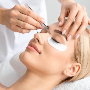 Stylistin bei der Wimpernverlängerung in modernem Beauty-Studio