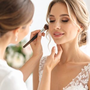 Braut beim Make-up und Hairstyling für ihren großen Tag